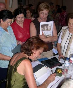 La profesora Concepción Lomba firma ejemplares del último libro publicado por la asociación cultural El Hocino en el año 2005