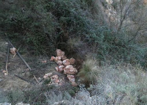 alud de piedras en la acequia