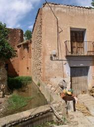 Fachada y balsa antes de su restauración. A la izquierda de la puerta está dibujado el relieve de una muela